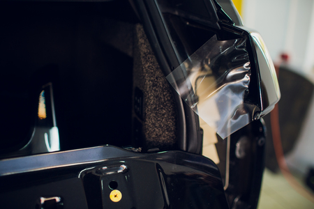 Worker hands installs car paint protection film wrapの写真素材