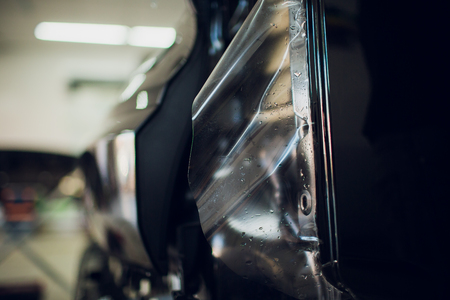 Worker hands installs car paint protection film wrapの写真素材