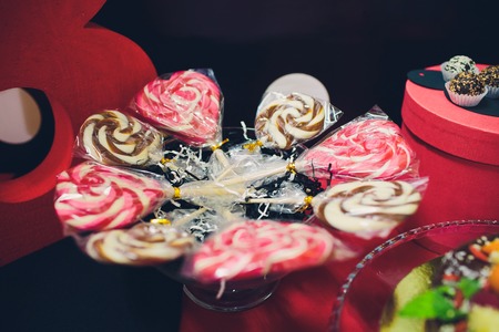 Chocolate heart shaped candies on sticks on wooden backgroundの写真素材