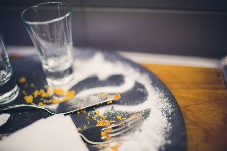 Empty white plate and spoon with crumbs and fat stains after vanilla cream cake was eatenの写真素材