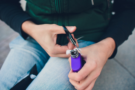 Maintenance of electronic mech mod vaping device.Modern vaporizer e-cig gadget to vape glycerin e-liquid.Vaper device repair service.Master replace wire for smoking.Ecig rapairing processの写真素材