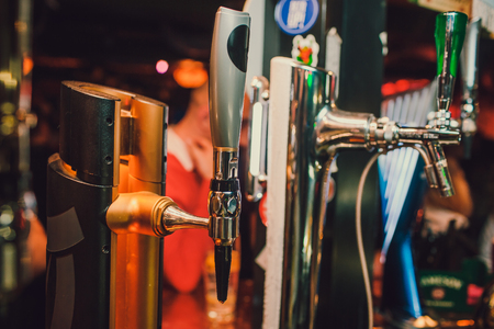 Barman hands pouring a lager beer in a glassの写真素材
