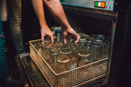 Discharging clean and shiny glasses from the dishwasherの写真素材