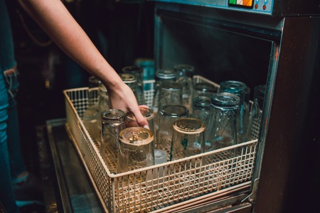 Discharging clean and shiny glasses from the dishwasherの写真素材