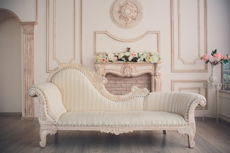 Interior with vintage furniture, light spring studio with beautiful white sofa and flowers in vases....