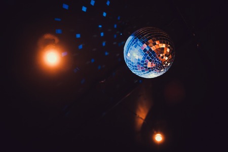 Disco ball with bright rays, night party background photoの写真素材