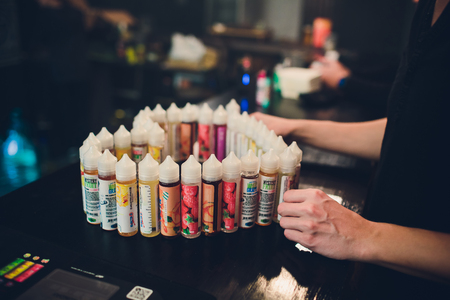 Ufa, Russia, South Vape Shop, 5 November, 2018: E-liquid e-juice High vape for electronic cigarette vaping device , on counter in smoke vapor in vape bar in bottles.のeditorial素材