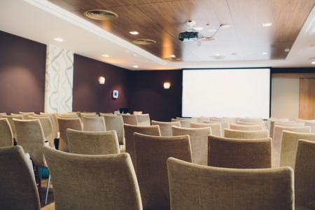 background of row of white seats. Empty hairs in the conference hall
