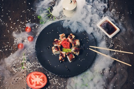 various sushi on white plate with chopsticks on wooden background.の写真素材