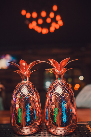 Two cocktails in the pineapple form cups on the bar counter.の写真素材
