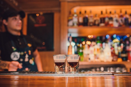 Bartender making shots on black bar with reflection.の写真素材