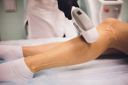 Hair removal cosmetology procedure from a therapist at cosmetic beauty spa clinic. Laser epilation. Cosmetology and SPA concept.の写真素材