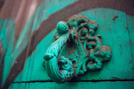 A green door with beautiful bronze retro style carved lion head handle.の写真素材
