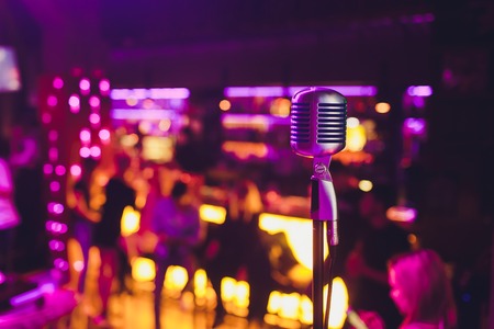 Retro microphone against blur colorful light restaurant background.の写真素材