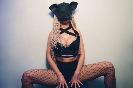 Swine mascot costume dance striptease woman in black leather pig mask.の写真素材