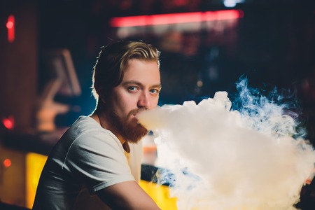 Young Man Smoking Shisha At Arabic Restaurant - Man Exhaling Smoke Inhaling From A Hookah.の写真素材