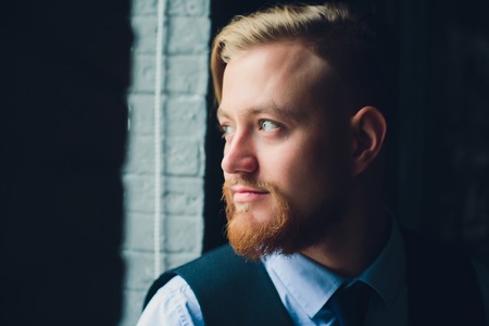 Portrait of blonde young man with uncommon appearance wears white t shirt.の写真素材