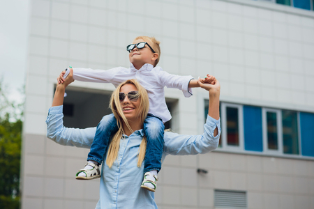 Young mother with her little boy outdoors on glass wallの写真素材
