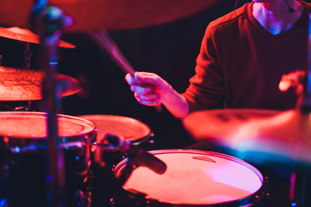 Human hands playing the drum with drumstickの写真素材