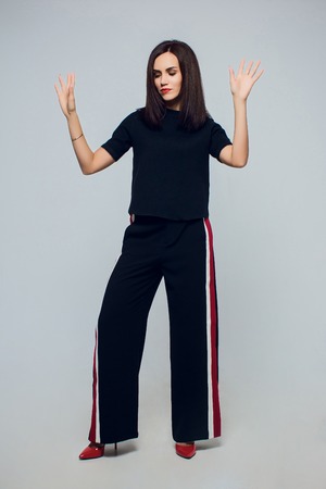 Full portrait of beautiful stylish girl in fashion stylish posing isolated on white background. Fashion model posing at studio. Full length portrait.の写真素材