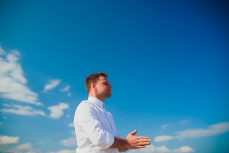 Handsome man wearing white clothes posing in sea sceneryの写真素材