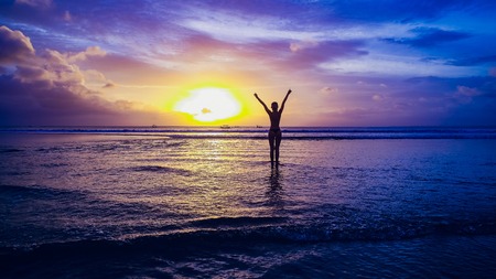 Beautiful girl on sunset background on sandy beachの写真素材