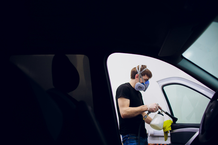 Handsome man cleaning car with hot steamの写真素材
