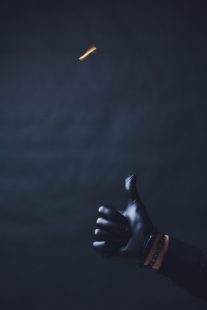 Bitcoin. Hand throws gold coin. Hands in black gloves. Concept rise crypto currency. Isolated on black background.の写真素材