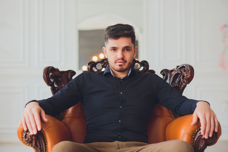 Handsome young man home sitting on couchの写真素材