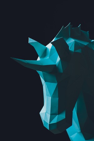 Unicorn turquoise head paper isolated on black background. Copy space.