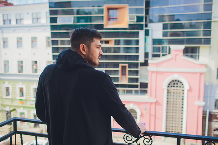 young man on balcony against southern skyの写真素材