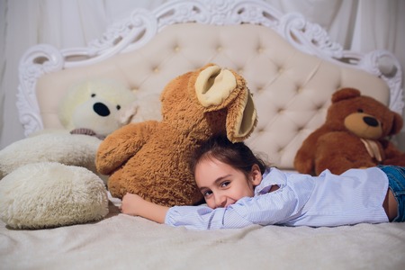 Cute happy little girl playing with toys and dreaming in teepee and bed.の写真素材