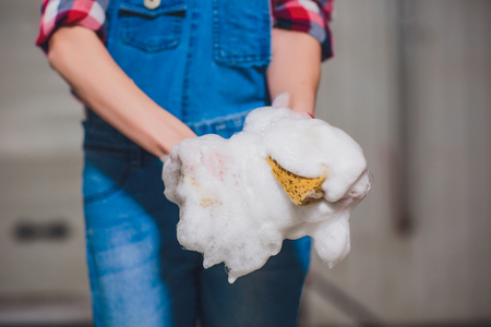 hand hold sponge over car for washingの写真素材