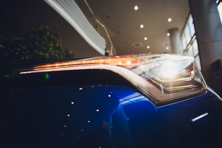 Close up shot headlight in luxury blue car background. Modern and expensive sport car conceptの写真素材