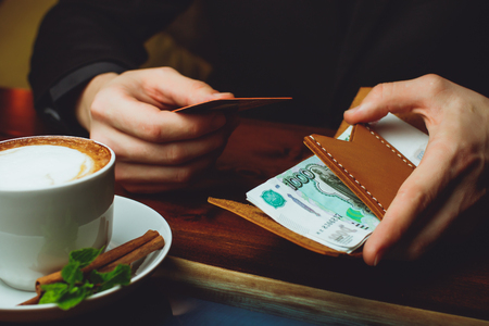 Hands take out russian rubles from wallet. Closeup on a man's hands as he is getting a banknote out of his walletの写真素材