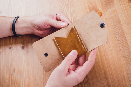 leather craftsman working making products at table in workshop studio
