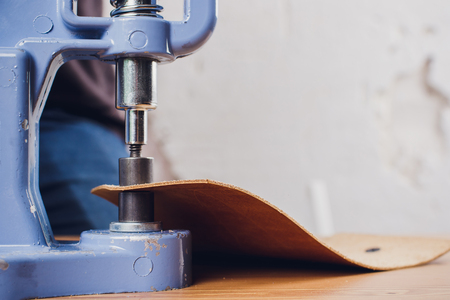 leather craftsman working making products at table in workshop studio
