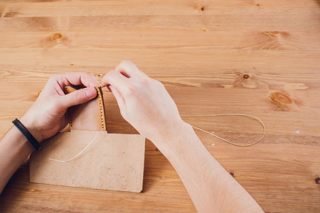leather craftsman working making products at table in workshop studioの写真素材