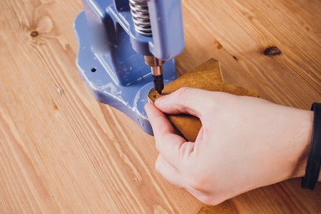 leather craftsman working making products at table in workshop studioの写真素材