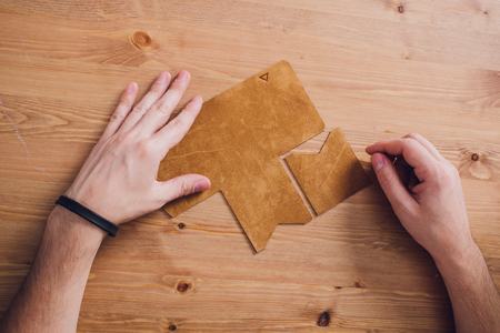 leather craftsman working making products at table in workshop studio
