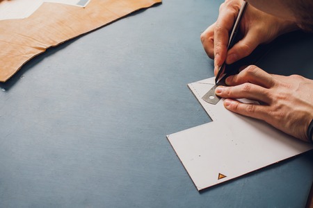 leather craftsman working making products at table in workshop studio