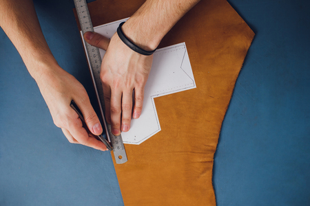leather craftsman working making products at table in workshop studio