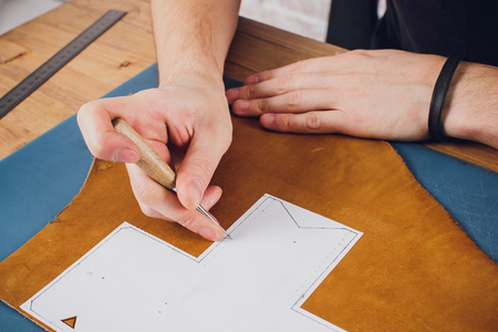 leather craftsman working making products at table in workshop studioの写真素材