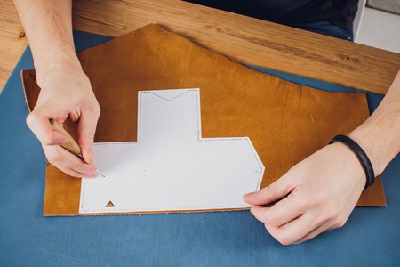 leather craftsman working making products at table in workshop studioの写真素材