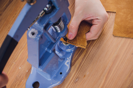 leather craftsman working making products at table in workshop studioの写真素材