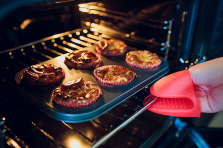 Woman baking cupcakes in the oven handの写真素材