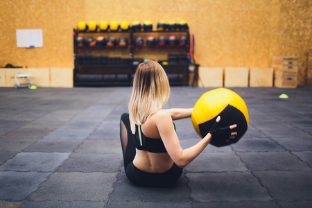 Female fitness model exercising with medicine ball at gym. Young woman doing workout using fitness ballの写真素材