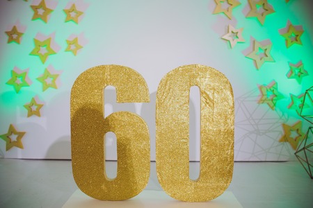 Piece of Birthday Chocolate Cake with Burning Candle as a Number Sixty on Silver Backgroundの写真素材