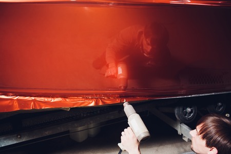 Car wrapping specialist putting vinyl foil or film on car. Selective focus.の写真素材