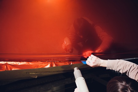 Car wrapping specialist putting vinyl foil or film on car. Selective focus.の写真素材